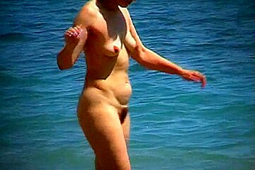 Beach nudist strips clothes and gets...