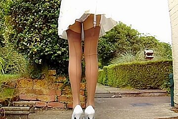 Tan Stockings With Pleated Skirt On A Windy Day...
