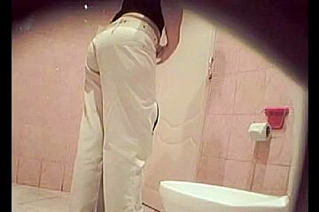 A Woman Wearing White Jeans Is The Public Toilet...