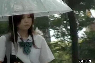 Asian schoolgirl gets on a rainy...