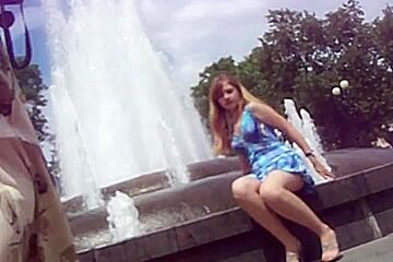 Blue dress sitting fountain...
