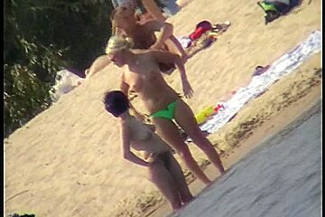 Couple cuddling naked on the nudist beach on spy cam