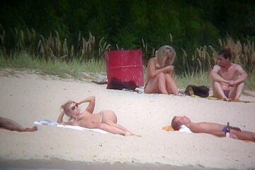 Nude couples are relaxing on a nudist beach here