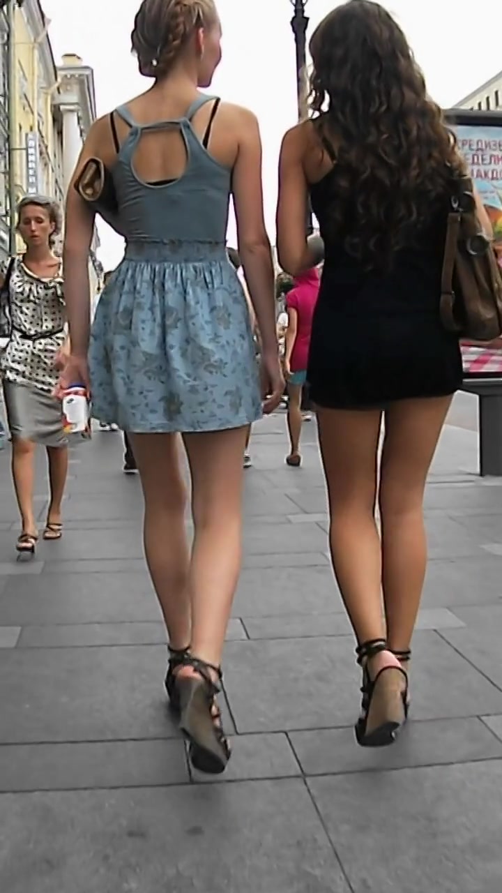 A voyeur takes upskirt shots while walking in the streets