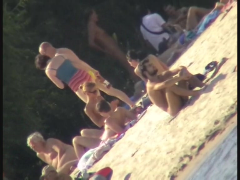 Sexy chick tanning naked on the beach and caught on cam
